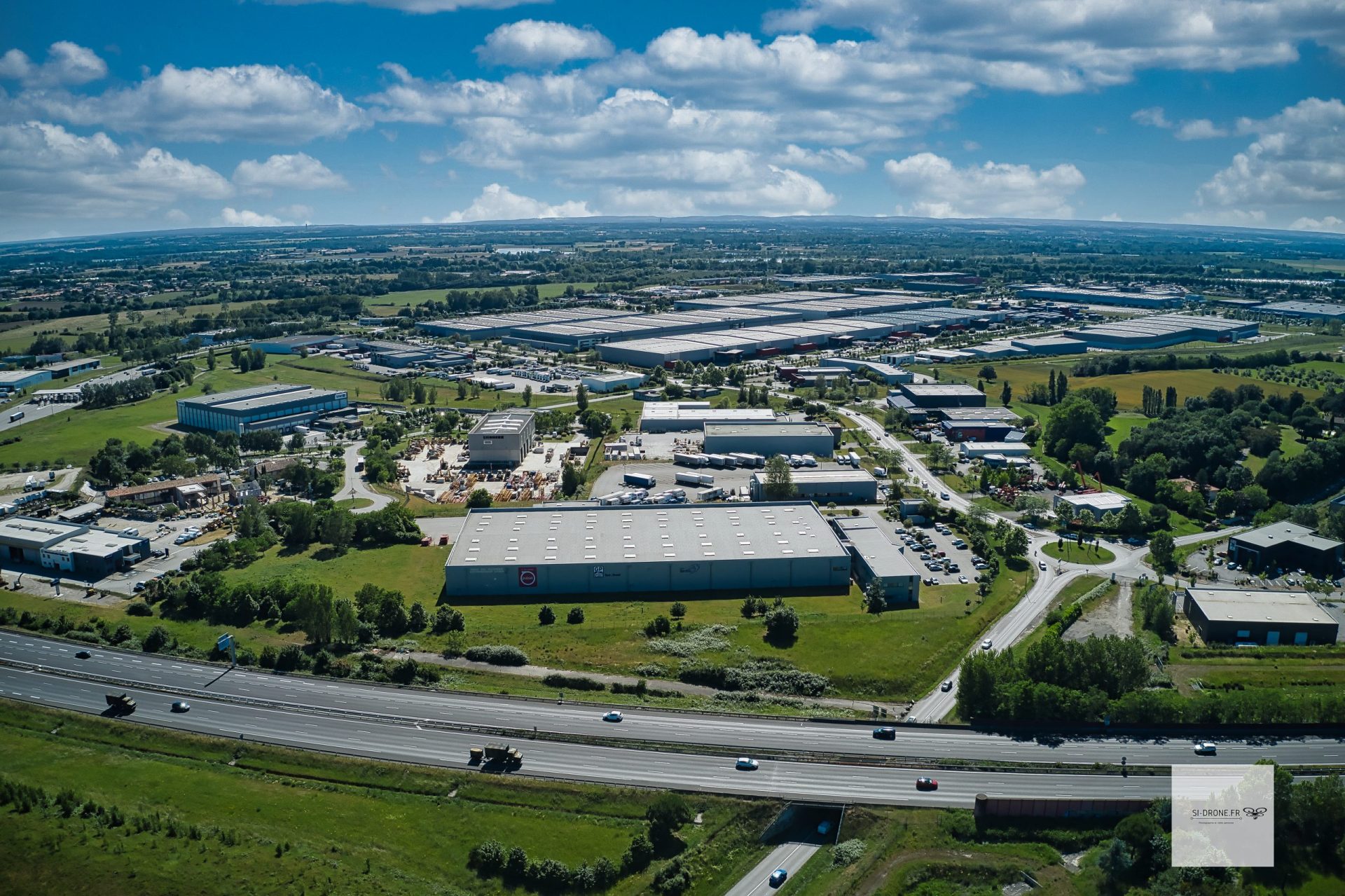 Vue aérienne de bâtiments d’activité et d’entrepôts dans une zone industrielle.