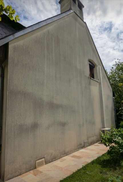 Façade immeuble noircie par la pollution et les algues rouges avant nettoyage